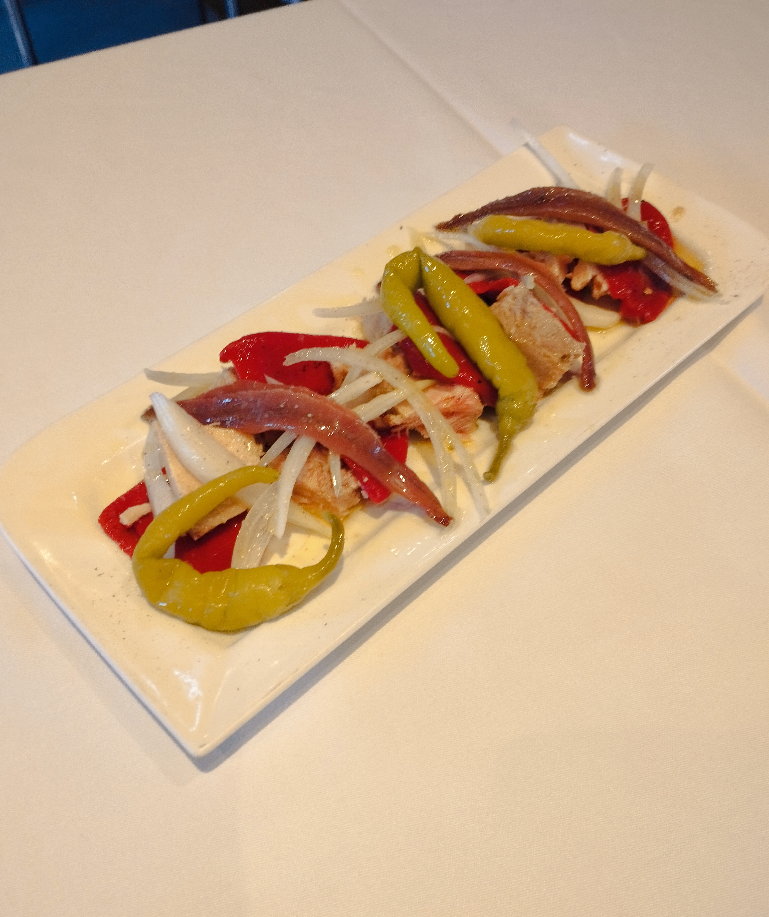 Anchoas sobre una cama de bonito y pimientos piquillo